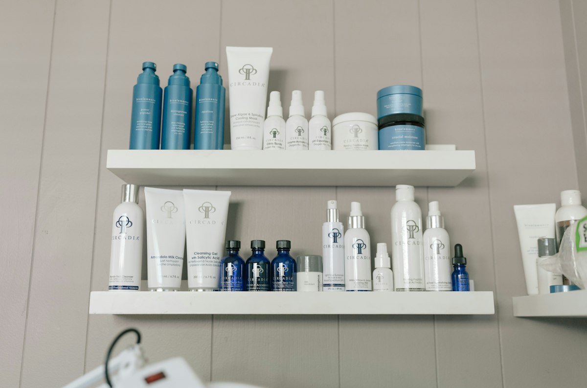 Skin-care bottles arranged on bathroom shelves