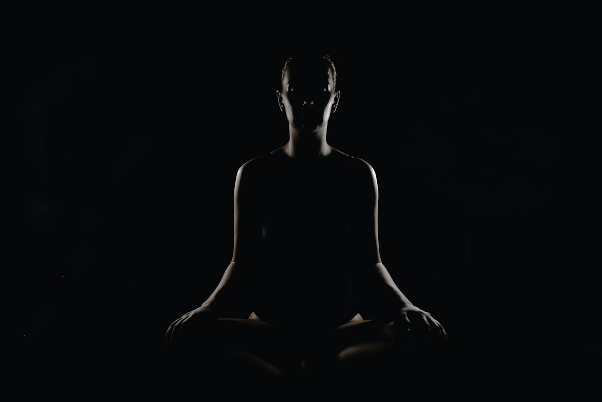 Silhouette of a person seated quietly in a meditation pose