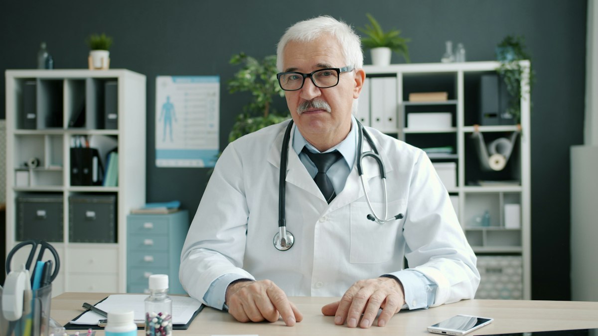 A doctor seated at a desk during a consultation
