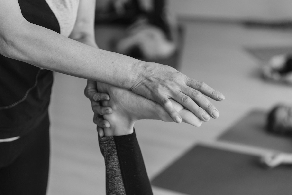 A practitioner supporting a person’s wrist during hand care