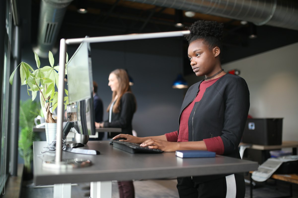 A woman working at an adjustable standing desk